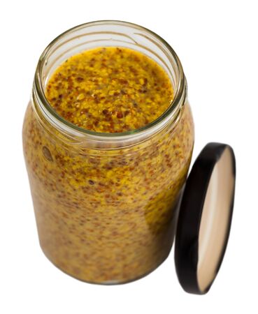 Soft and mild grainy mustard in open glass jar. Isolated over white backgroundの写真素材