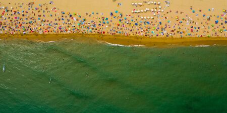 Top aerial view of crowded sandy sea beach in summer sunny dayの写真素材