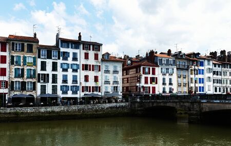Panoramic scenic view of old houses at quay of Nive river in Bayonne, Franceの写真素材