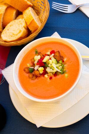 Traditional Spanish refreshing pureed soup gazpacho from tomatoes served with fried bread and chopped vegetablesの写真素材