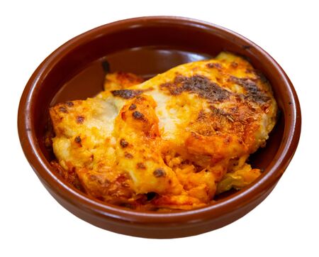 Italian meat lasagna in a clay plate. Isolated over white backgroundの写真素材