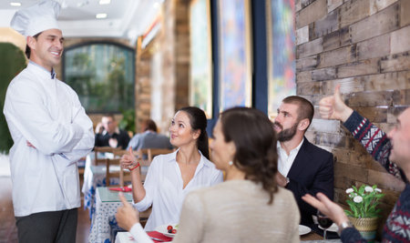 Professional cook chef talking with guests in the restaurant