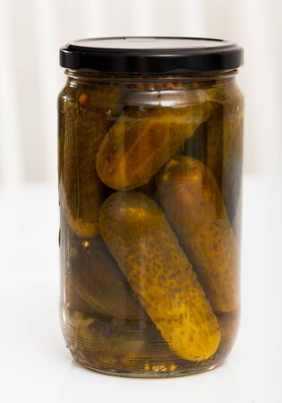 Glass jar with pickled cucumbers on white backgroundの写真素材