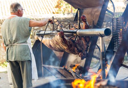 BESALU, SPAIN - SEPTEMBER 02, 2017: Chef cooking on fire whole bull carcass for guests on Medieval Fiestaのeditorial素材