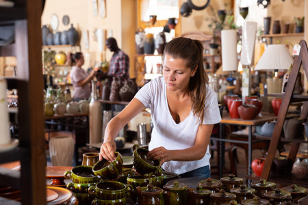 Girl visiting souvenir shop and choosing earthenwareの写真素材