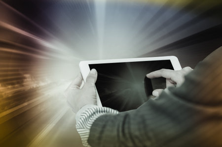 Female hands pressing on tablet screen on background of bright divergent rays