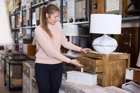 Female standing near commode in the furniture store before the buyingの写真素材