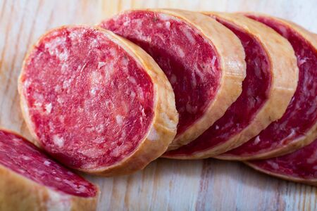Salchichon spanish sausage slices on wooden desk, view from topの写真素材