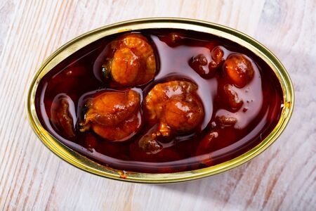 Tasty canned scallops in scallops sauce served on tableの写真素材