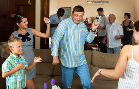 Big happy multiethnic family gathering in parental home during family party, dancing and discussing pleasant topicsの写真素材