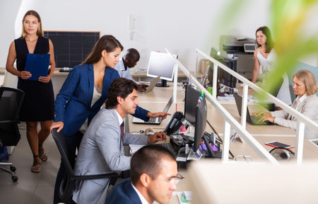 International business team working and communicating together in modern open plan office