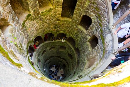 SINTRA, PORTUGAL - APRIL 21, 2019:  Looking down Initiation well of Quinta da Regaleira with stony stairs and arched galleryのeditorial素材