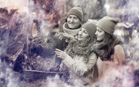 Happy european family of three with teenage girl choosing  floral decorations  at market. Shallow depth of focusの写真素材