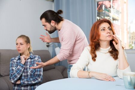 Portrait of sad mature woman sitting after conflict with adult children in home interiorの写真素材