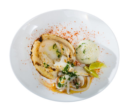 Dish of Mediterranean cuisine â€“ baked in oven cuttlefish, rice, lemon and parsley. Isolated...