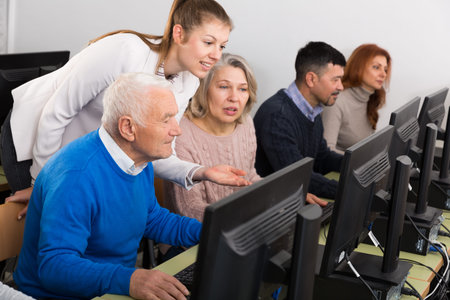 Business woman helping to partners, pointing at computer monitor in office