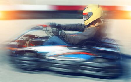 Happy cheerful positive  female go-cart racer at kart circuit outdoorsの写真素材