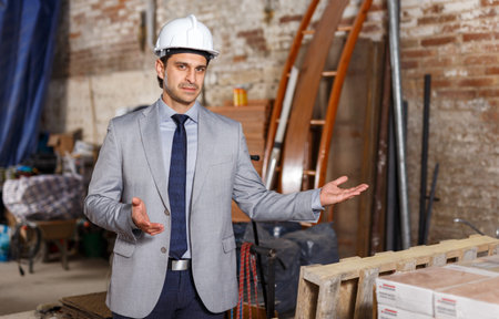 Portrait of friendly and welcoming man in suit and helmet at construction site