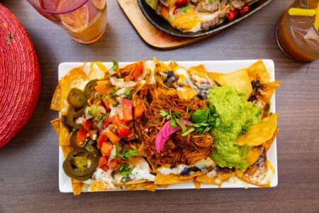 Traditional Mexican dish Nachos with meat, Guacamole sauce and vegetablesの写真素材