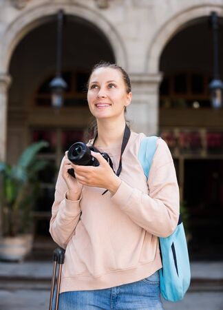 Smiling traveling woman walking looking curious in the cityの写真素材