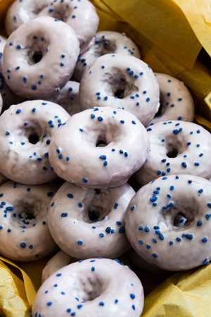 Box with delicious donuts with sugar icing and colorful sprinkling. Popular sweet bakeryの写真素材