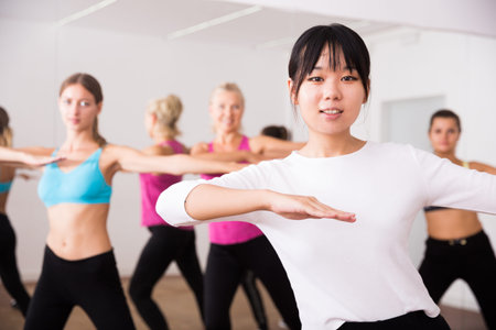 Girl of chinese appearance dances in a group of dancers