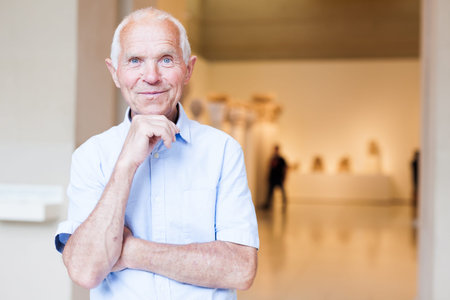 Portrait of thoughtful senior male exploring art pieces in gallery