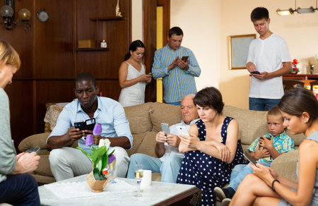 Portrait of big multigenerational family  using gadgets at home interior