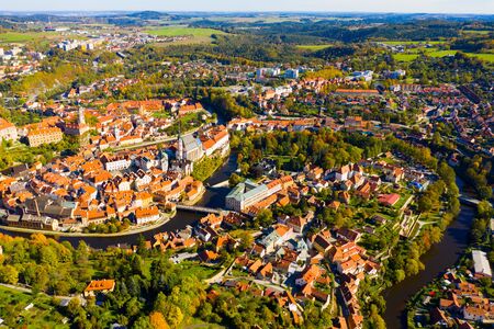 Scenic view from drone of old part of Czech town of Cesky Krumlov with brownish tiled roofs of houses, medieval Castle and Cathedral of Saint Vitusの写真素材