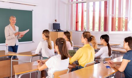 Portrait of female teacher lecturing to students at auditoriumの写真素材