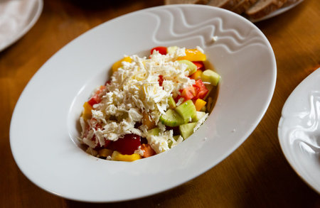 Dish of Balkan cuisine Shopska salad with cucumbers, tomatoes, bell peppers and brynza (salted sheep...