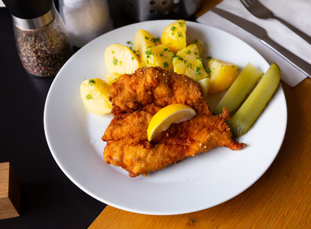Dish of Czech cuisine â chicken cutlet in parmesan breading served with boiled potato and pickleの写真素材
