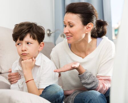 Loving mother consoling sad preteen son after home disagreementsの写真素材