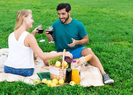 Couple are talking sitting and drinking wine in time picnic outdoor.の写真素材