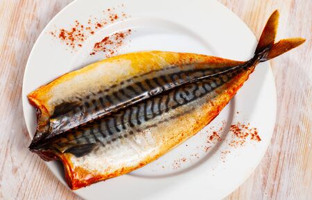 Appetizing hot smoked mackerel sprinkled with paprika served on white plateの写真素材