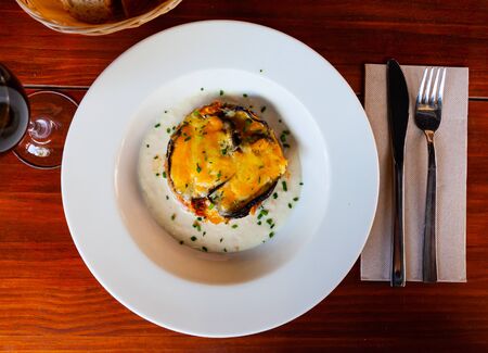 Top view of appetizing moussaka - baked aubergine with tuna, bechamel sauce and golden crust of grated cheese on white playの写真素材