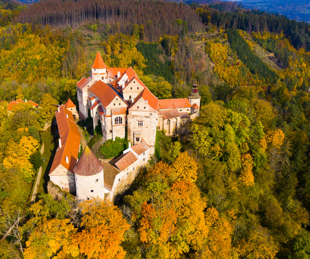 View from drone of autumn landscape overlooking ancient Pernstejn castle on hilltop between forests, Nedvedice, Czech Republicのeditorial素材
