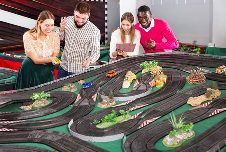 Girls with guys play together the slot car racing modelsの写真素材