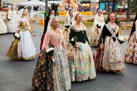 VALENCIA, SPAIN - MARCH 18, 2019: Costumed procession in colorful traditional dresses in city streets on annual spring Falles festivalのeditorial素材