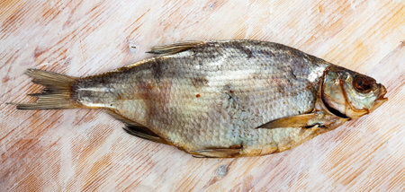 Whole dried salted bream fish on wooden background. Beer snack 