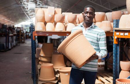 Portrait of African American man choosing pots for flowers and trees in gardening marketの写真素材
