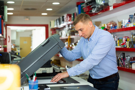 Confident businessman using printer in office