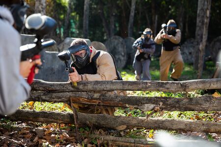 Portrait of team of adults playing on paintball battlefield outdoorの写真素材