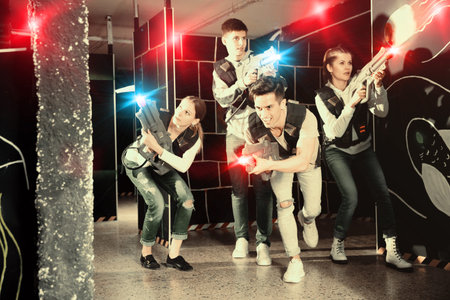 People in vests and with laser pistols playing emotionally laser