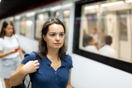 Attractive woman waiting for train in platform of underground station