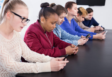 Fellow students playing with their smartphones during the school day