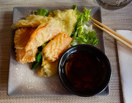 Closeup of tasty fried vegetable tempura served with lettuce, sauce and chopsticks

の写真素材