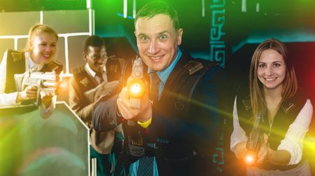 Modern man and his colleagues on background having corporative entertainment in laser tag room