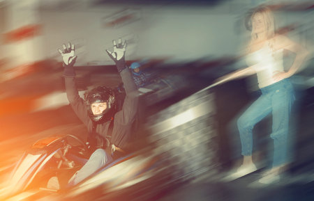 Happy cheerful  smiling man finishing race on racing car at kart circuit