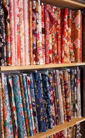 Rolls of fabric and textiles for sale stacked on shelves in shopのeditorial素材